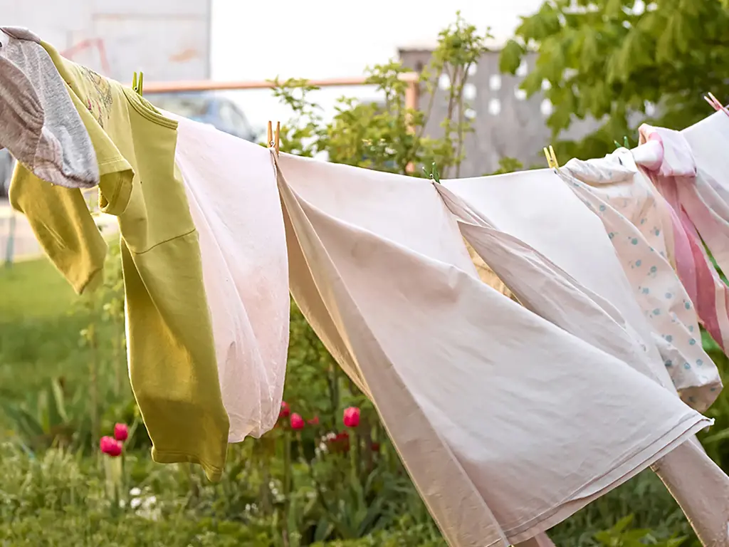 Linge suspendu à sécher sur un fil extérieur dans un jardin - réparation sèche-linge Genève, Suisse Dépannage