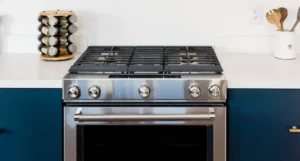 Cuisinière inox avec plaque de cuisson à gaz et four intégré dans une cuisine bleu marine - réparation cuisinière Genève, Suisse Dépannage
